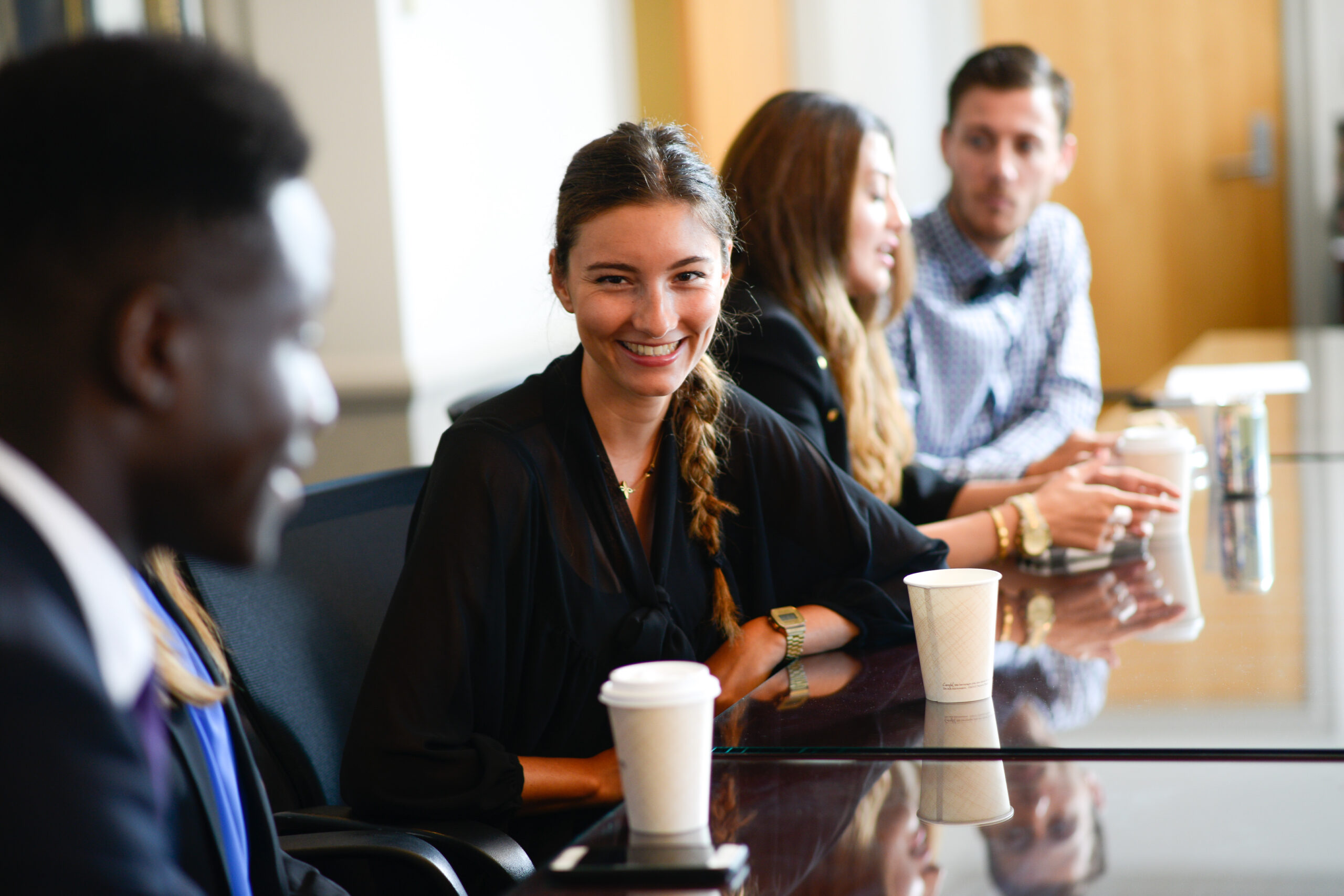 Header for Internship Page and Serves as a link to the Career Page - Student smiling at conference table