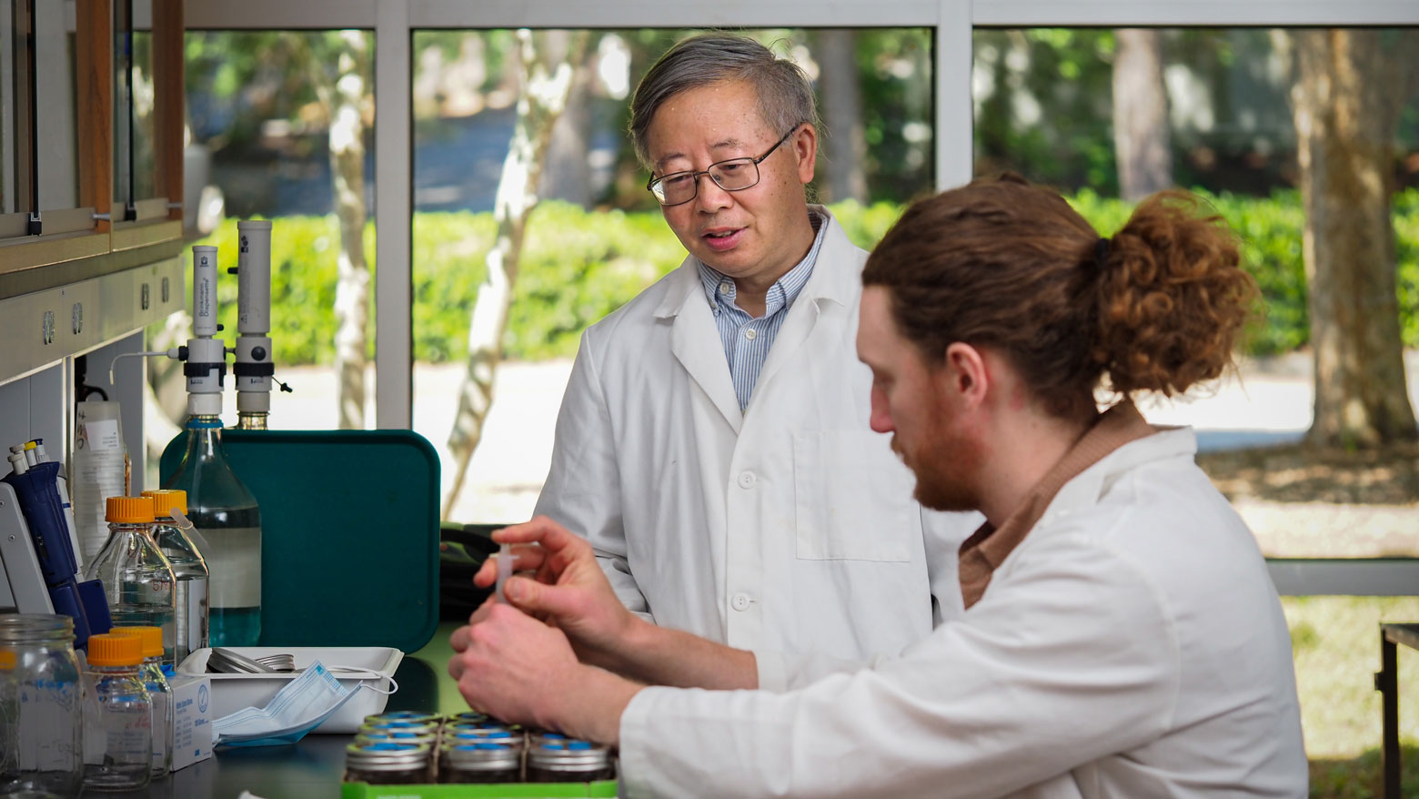 Header for news post - Shuijin Hu in lab with his student